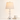Washed-white spindle table lamp next to a book and mug for scale, lamp on