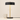 Black disc table lamp next to a ceramic mug for scale, shade on