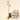 Brass triple-spot tree floor lamp next to a chair for scale, lit
