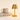 Brass cordless table lamp next to a book for scale, shade on