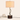 Walnut twist table lamp next to a book for scale, shade on