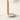 Close-up of the white marble disc base, light wood cylinder, brass neck, and cord