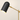 Close-up of the matte-black pill shade and brass crane arm, lamp on