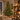 Full Christmas tree by a fireplace, shown with lights and ornaments added