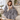 Woman on a sofa with a mug under the gray sherpa heated throw blanket