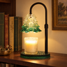 Green Glass Tree Candle Warmer Lamp glowing on a walnut shelf beside old books