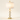 White marble table lamp with four stacked discs, gold stem, and a white drum shade, lamp on
