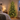 Pre-lit green Christmas tree glowing in a bedroom corner